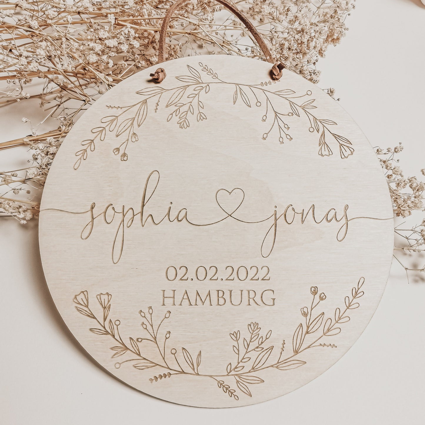 Mit Namen des Brautpaares, sowie Datum und Ort der Hochzeit personalisiertes Holzschild mit Blumen Verzierung  – Graviertes Hochzeitsgeschenk aus Holz